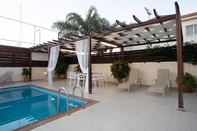 a patio with a pool and a table and chairs at Athena Villa in Ayia Napa