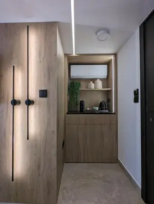 a kitchen with wooden cabinets and a mirror at Tuck Inn in Larnaka