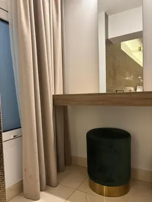 a bathroom with a mirror and a green stool at Tuck Inn in Larnaka