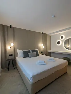 a bedroom with a large white bed and a table at Tuck Inn in Larnaka