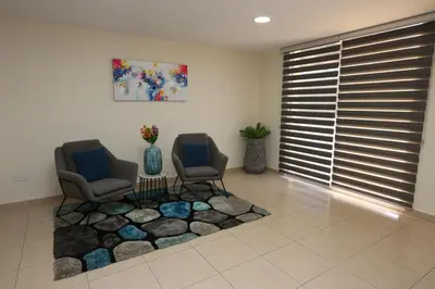 a living room with two chairs and a table at Sunquest Gardens Holiday Resort in Limassol