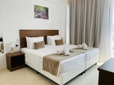 a bedroom with two beds with white sheets at Lysithea Hotel in Larnaka