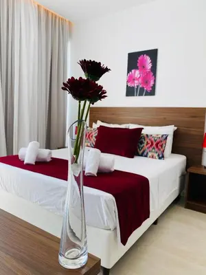 a bedroom with two beds with a vase with flowers at Lysithea Hotel in Larnaka