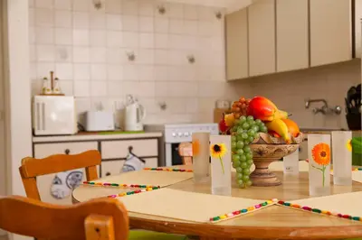 a kitchen table with a bowl of fruit and a vase of flowers at Annita Court Bock B, Apt3 in Ayia Napa