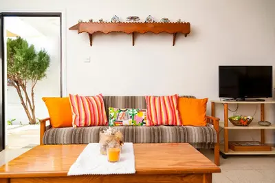a living room with a couch with orange pillows at Annita Court Bock B, Apt3 in Ayia Napa