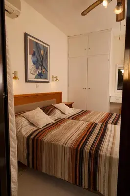 a bedroom with a large bed with a striped blanket at Annita Court Bock B, Apt3 in Ayia Napa