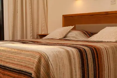 a bed with a blanket and pillows on it at Annita Court Bock B, Apt3 in Ayia Napa