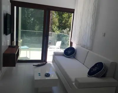 a living room with a couch and a large window at Modern Seaview Beach Studio Limassol in Limassol
