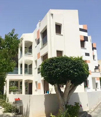 a white building with a tree in front of it at Modern Seaview Beach Studio Limassol in Limassol