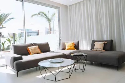 a living room with a couch and two tables at Vivo Mare Beachfornt Villas - Azure in Ayia Napa