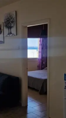 a bedroom with a bed and a window with the ocean at Serenity by the sea in Larnaka