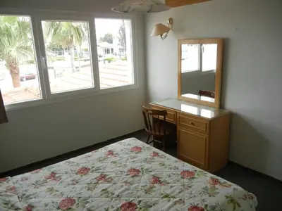 a bedroom with a bed and a desk and a mirror at Tsialis Hotel Apartments in Larnaka