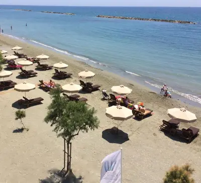 an overhead view of a beach with tables and umbrellas at Olympic Residence Deluxe Apartments in Limassol