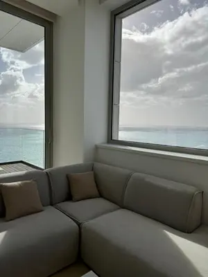 a living room with a couch and a large window at Olympic Residence Deluxe Apartments in Limassol