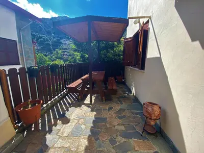 a patio with a wooden table and an umbrella at Gold Mountain House in Moutoullas