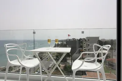 two chairs and a table with wine glasses on a window at The White Pearl Suite - beach front city centre with sea view. in Limassol