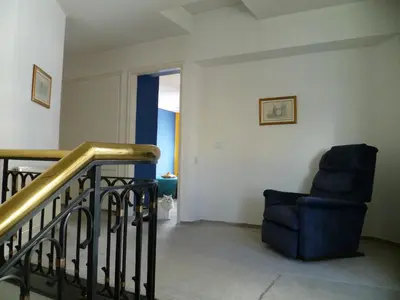 a living room with a staircase and a chair at Double room with ensuite bathroom at Datacom building in Nicosia
