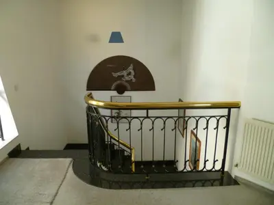 a stairway with a railing and a clock on the wall at Double room with ensuite bathroom at Datacom building in Nicosia