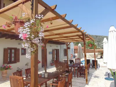 a wooden pavilion with tables and chairs and flowers at Charalambos Holiday Cottage in Kalavasos