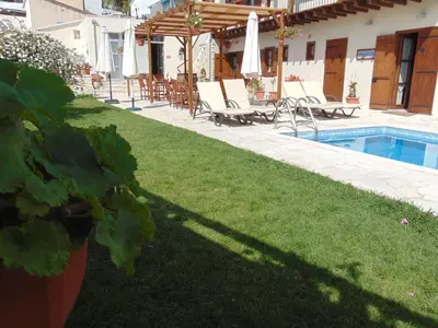 a yard with chairs and a swimming pool at Charalambos Holiday Cottage in Kalavasos