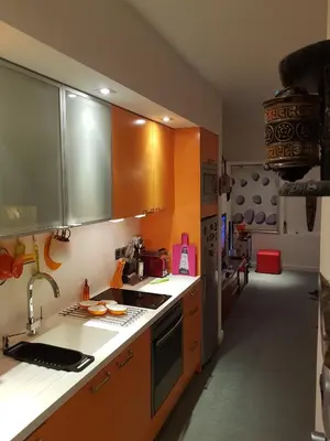 a kitchen with orange cabinets and a sink at Sylvias art studio apt in Ayia Napa
