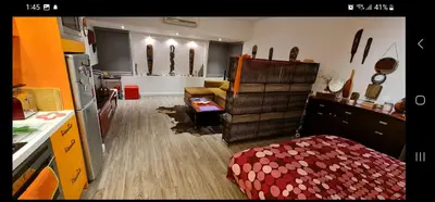 a kitchen with a couch and a table in a room at Sylvias art studio apt in Ayia Napa