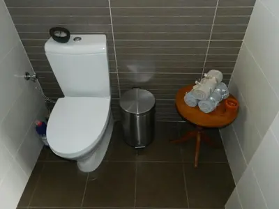 a small bathroom with a toilet and a table at Family Nest In The Heart Of Limassol in Limassol