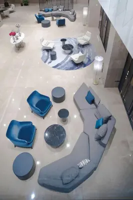 a living room with blue chairs and a table at Radisson Blu Hotel, Larnaca in Larnaka