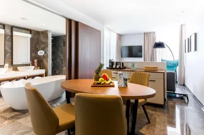 a room with a table and chairs and a bathroom at Radisson Blu Hotel, Larnaca in Larnaka