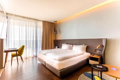 a hotel room with a bed and a table and a desk at Radisson Blu Hotel, Larnaca in Larnaka