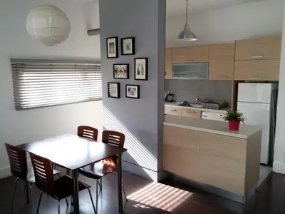 a kitchen with a table and chairs and a refrigerator at The Kapitani Residence in Nicosia
