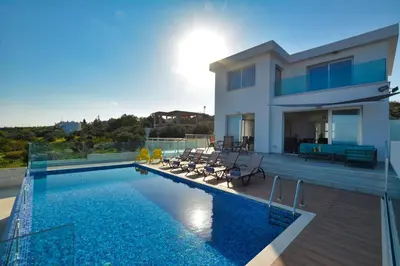 a villa with a swimming pool and a house at Aetopetra Villa in Protaras