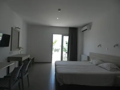 a hotel room with a bed and a table and chairs at Evabelle Napa Hotel Apartments in Ayia Napa