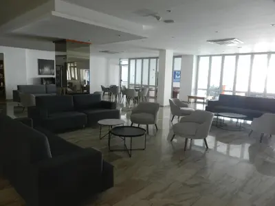 a waiting room with couches and tables and windows at Evabelle Napa Hotel Apartments in Ayia Napa