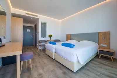 a hotel room with a large bed and a kitchen at Protaras Plaza Hotel in Protaras