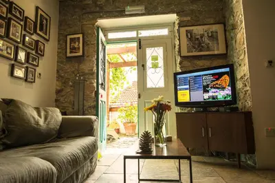 a living room with a couch and a tv at Anastou's Traditional House in Kalopanayiotis