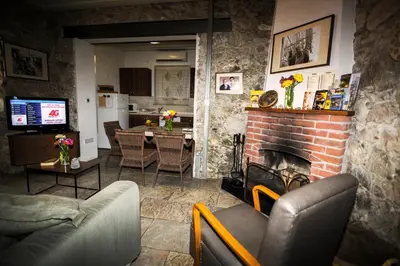 a living room with a fireplace and a dining room at Anastou's Traditional House in Kalopanayiotis
