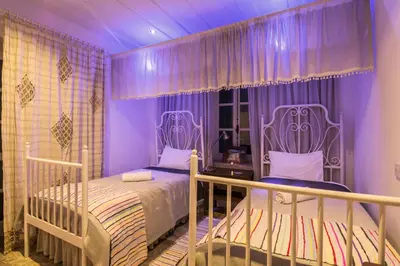 a purple bedroom with a bed and two chairs at Anastou's Traditional House in Kalopanayiotis
