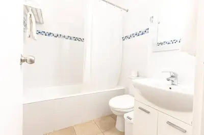 a white bathroom with a toilet and a sink at Vrissaki Hotel Apartments in Protaras