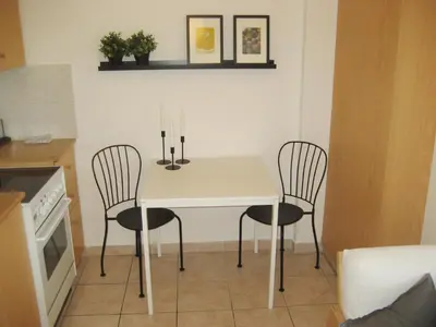 a kitchen with a white table and two chairs at Lykavitos Apartments in Nicosia