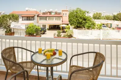 a table with fruit and drinks on a balcony at MyNapa Apartments in Ayia Napa