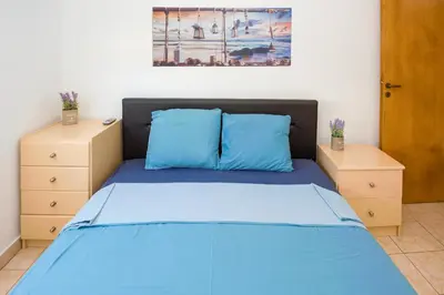 a bedroom with a blue bed with two night stands at MyNapa Apartments in Ayia Napa