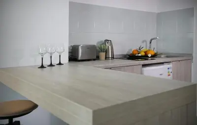 a kitchen with a counter with wine glasses on it at Pier Beach Hotel Apartments in Limassol