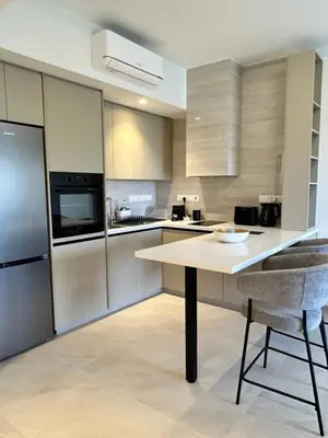 a kitchen with a table and some chairs in it at Pigeon Beach Hotel Apartments in Limassol