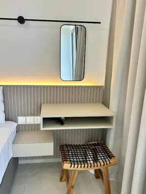 a dressing table with a mirror and a stool at Pigeon Beach Hotel Apartments in Limassol