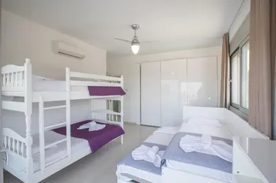 a bedroom with white bunk beds and a purple bed at Villa Gardenia in Protaras