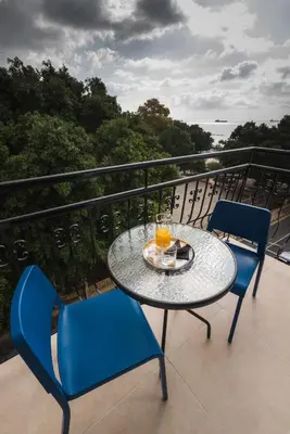 a table and chairs on a balcony with a table and drinks at Chrielka Hotel in Limassol