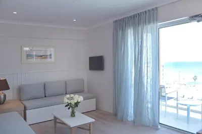 a living room with a couch and a large window at Sunrise Gardens Aparthotel in Protaras