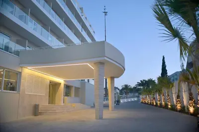 an external view of a building with palm trees at Sunrise Gardens Aparthotel in Protaras