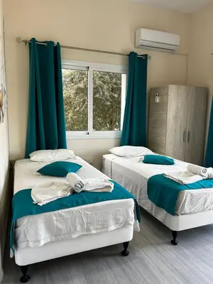 two beds in a room with green curtains at Lucky 5 in Paralimni